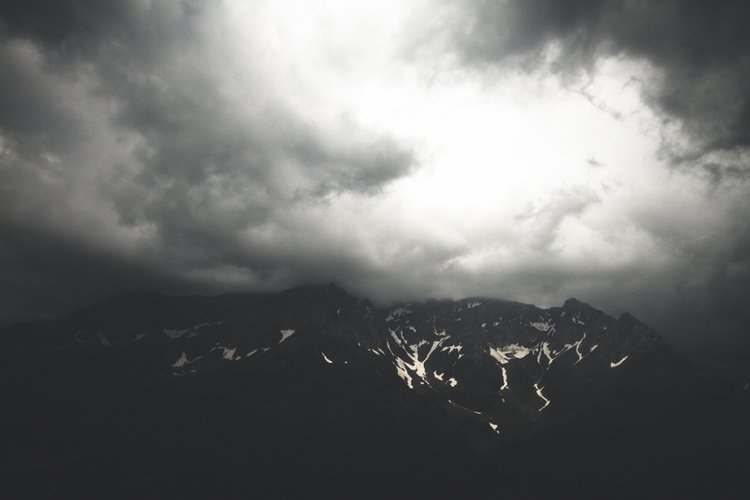 Dark cloudy sky over a snow-capped mountain range